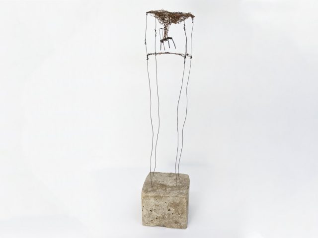 Wire and concrete sculpture of chair in cube with cloud coming from chair
